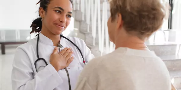 médica com a mão no peito fala com paciente