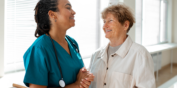 Médica e paciente idosa sorridentes