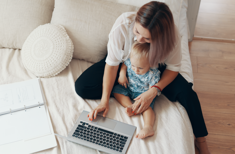 Mulher com bebê na cama usando a tecnologia na saúde