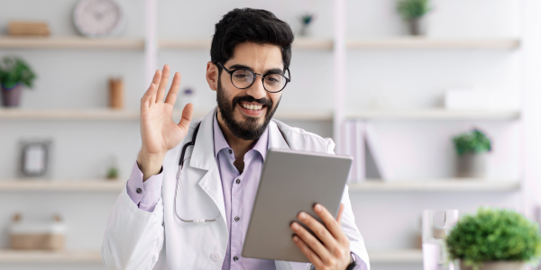 médico acena para paciente em telemedicina